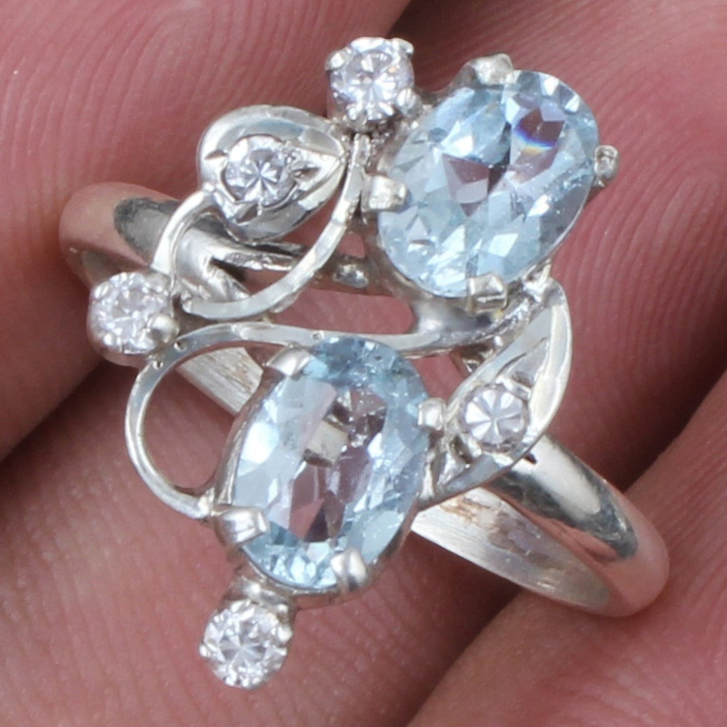 Jewels and art Emporium india silver ring with two oval blue topaz stones and small clear cubic zirconia accents, prong set.